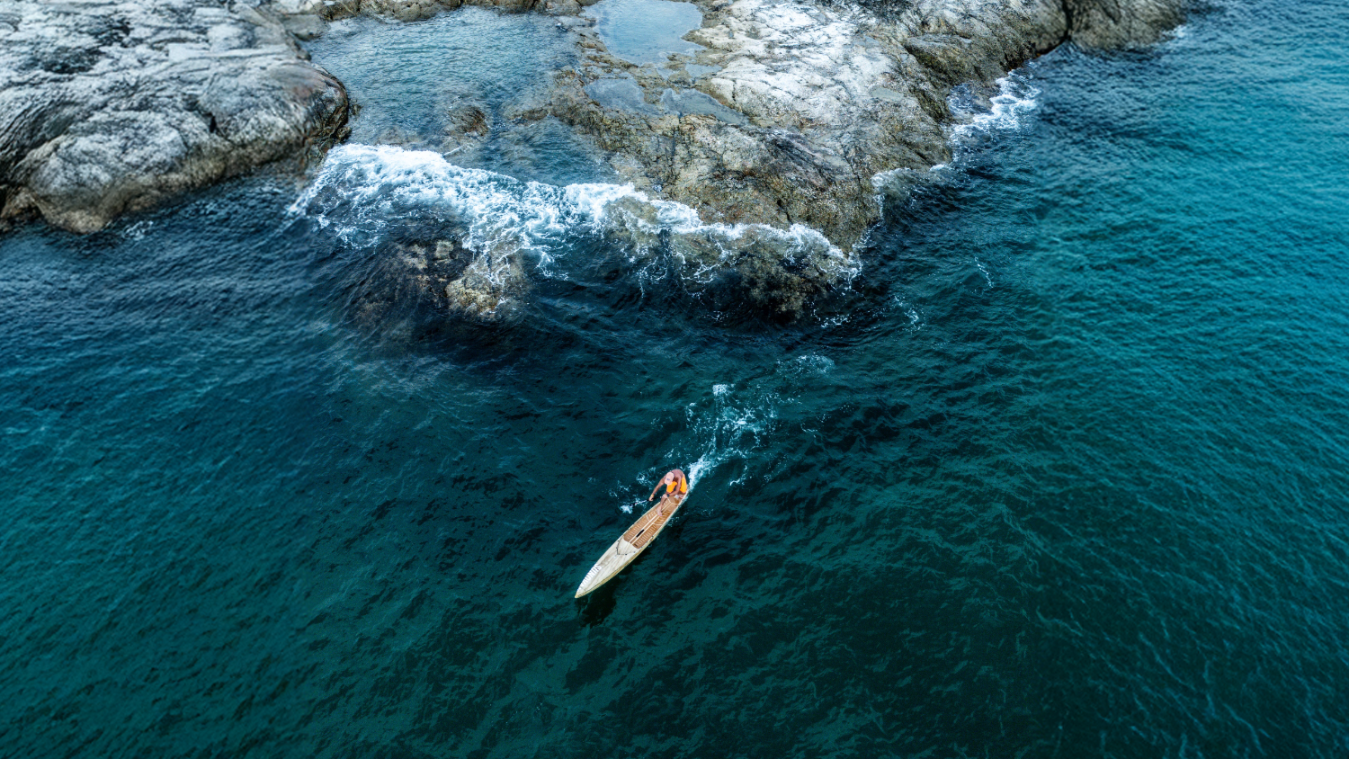 Lighthouse on a rocky island with a SUP surf board in the foreground