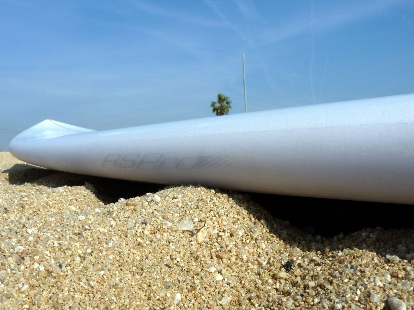 Surfboard laying on beach sand with Surf RSPro rail protection